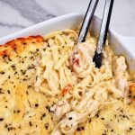 Chicken Tetrazzini served with tongs.