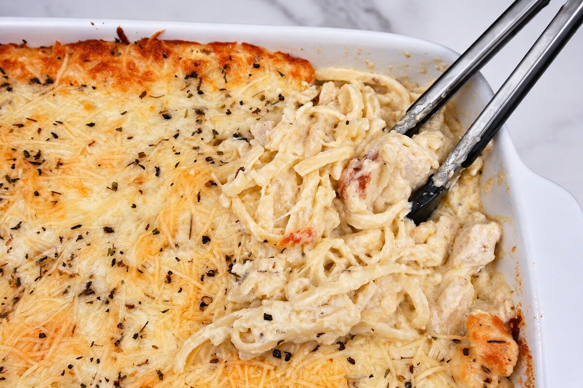 Chicken Tetrazzini served with tongs.