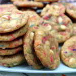 sprinkle cookies baked and stacked on a blue plate.