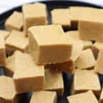 peanut butter fudge slices on a black plate.