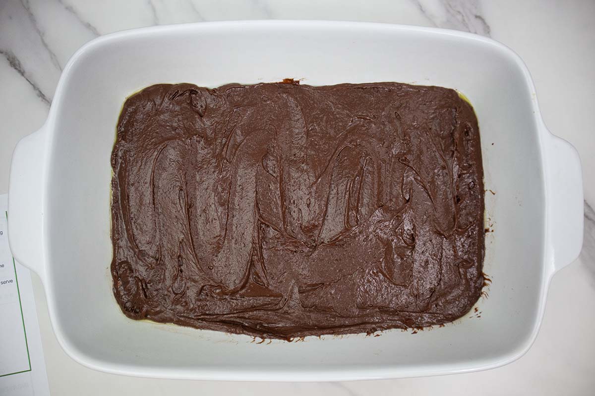 hot fudge cake batter spread into a glass baking dish.