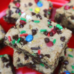 cookie bars cut into squares and stacked on a red plate.