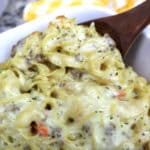 philly cheesesteak casserole served with a wooden spoon.