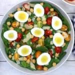 spinach salad in a large white bowl.