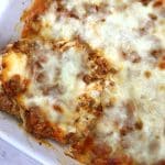 lazy lasagna in white baking dish with bamboo spoon.