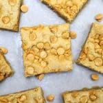 squares of butterscotch blondies on white parchment paper.
