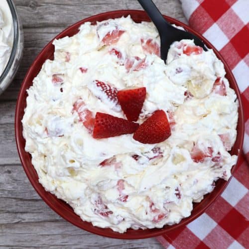 strawberry banana cheesecake salad in a red bowl.