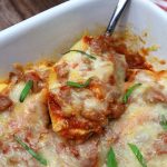 stuffed shells in a white baking dish.