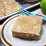 Slice of caramel apple sheet cake on a tan plate.