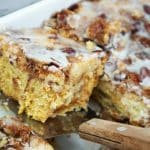 Sliced cinnamon roll dump cake on a metal spatula.