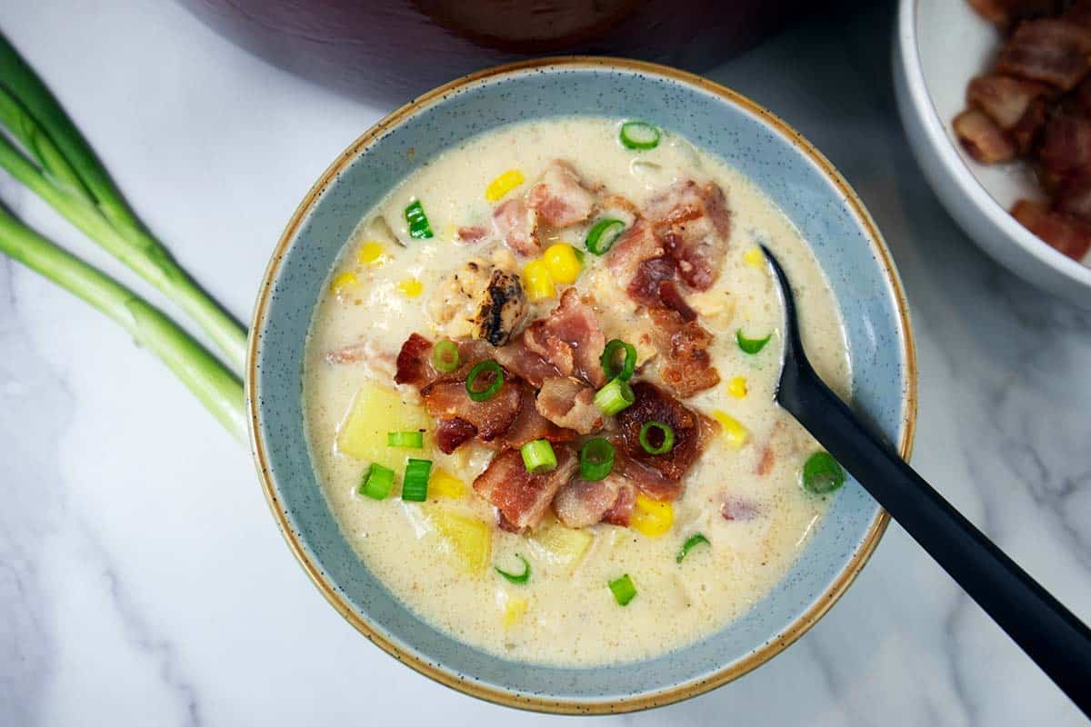 Chicken corn chowder soup in a blue bowl, ready to eat.