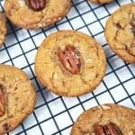 Butter pecan cookies on a black wire cooling rack.