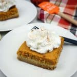 Pumpkin gooey cake slice with whipped cream on top.