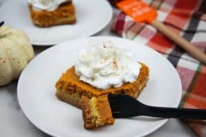 Pumpkin gooey cake slice with whipped cream on top.