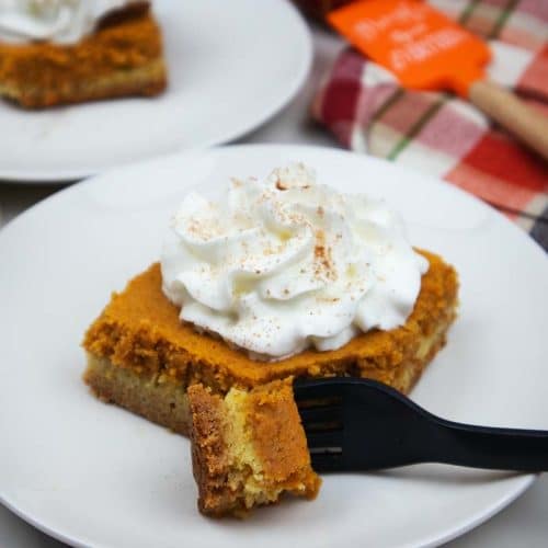 Pumpkin gooey cake slice with whipped cream on top.