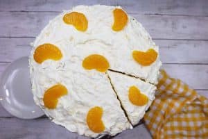 Pig Pickin Cake with mandarin oranges on top and a slice cut out.
